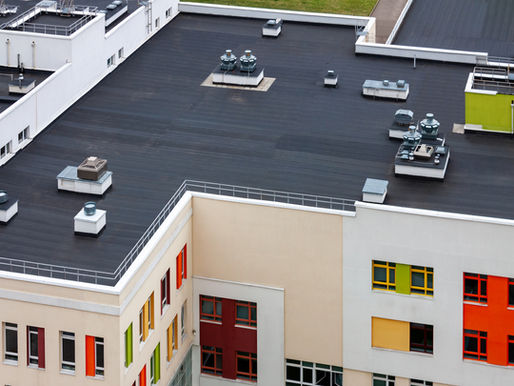 Flat rooftop with ventilation units. The building has colorful window frames in red, yellow, and green, emphasizing a modern design.