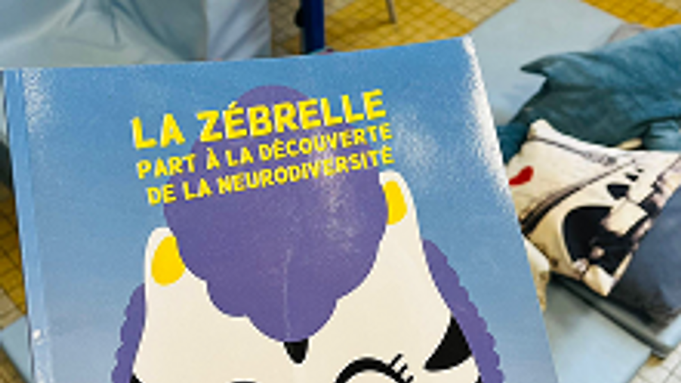 Une enseignante tient l'album jeunesse LA Zébrelle dans ses mains