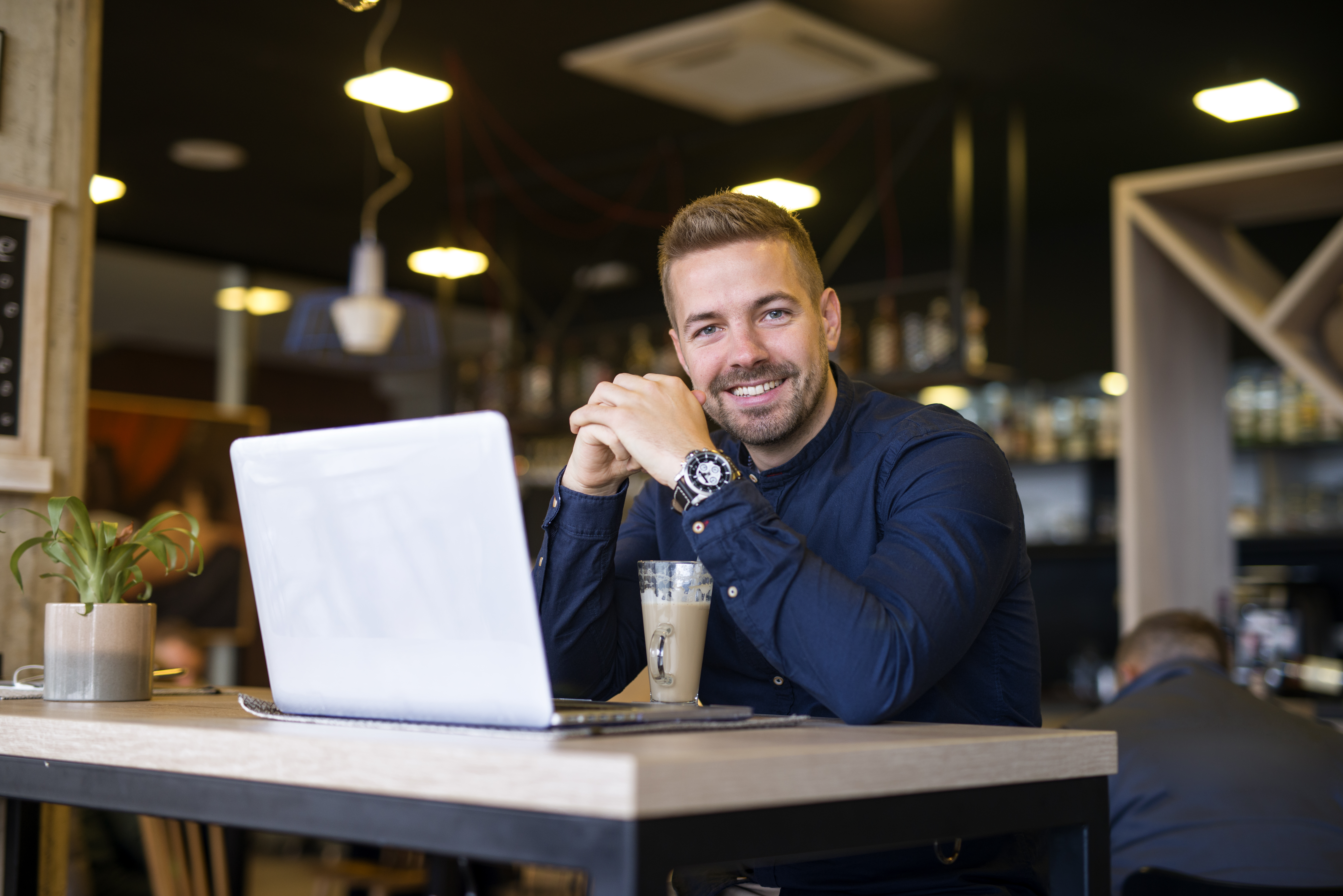 portrait-smiling-man-sitting-cafe-bar-with-his-laptop-computer.jpg