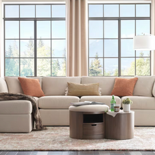 light-colored sectional with contrasting accent pillows, round accent coffee table