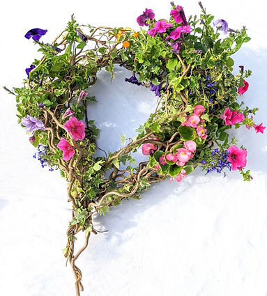 Rustic heart shaped funeral floral tribute with trailing ivy and flowers