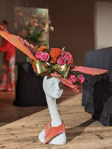 A dramatic hat using Livistonia Leaves and an aspidistra bow on a model head on a stage