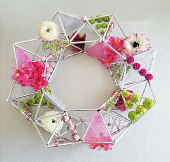 Decorative craft wreath made from drinking straws embellished with flowers