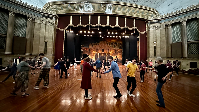 Picture of Alamo Stomp Dancers with social dancers in a ballroom.