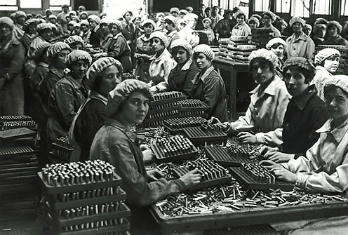 A group of women in a munitions factory, looking at the camera