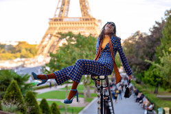 Modelo com boina e botas em pose elegante no Trocadéro, com vista para a Torre Eiffel em Paris
