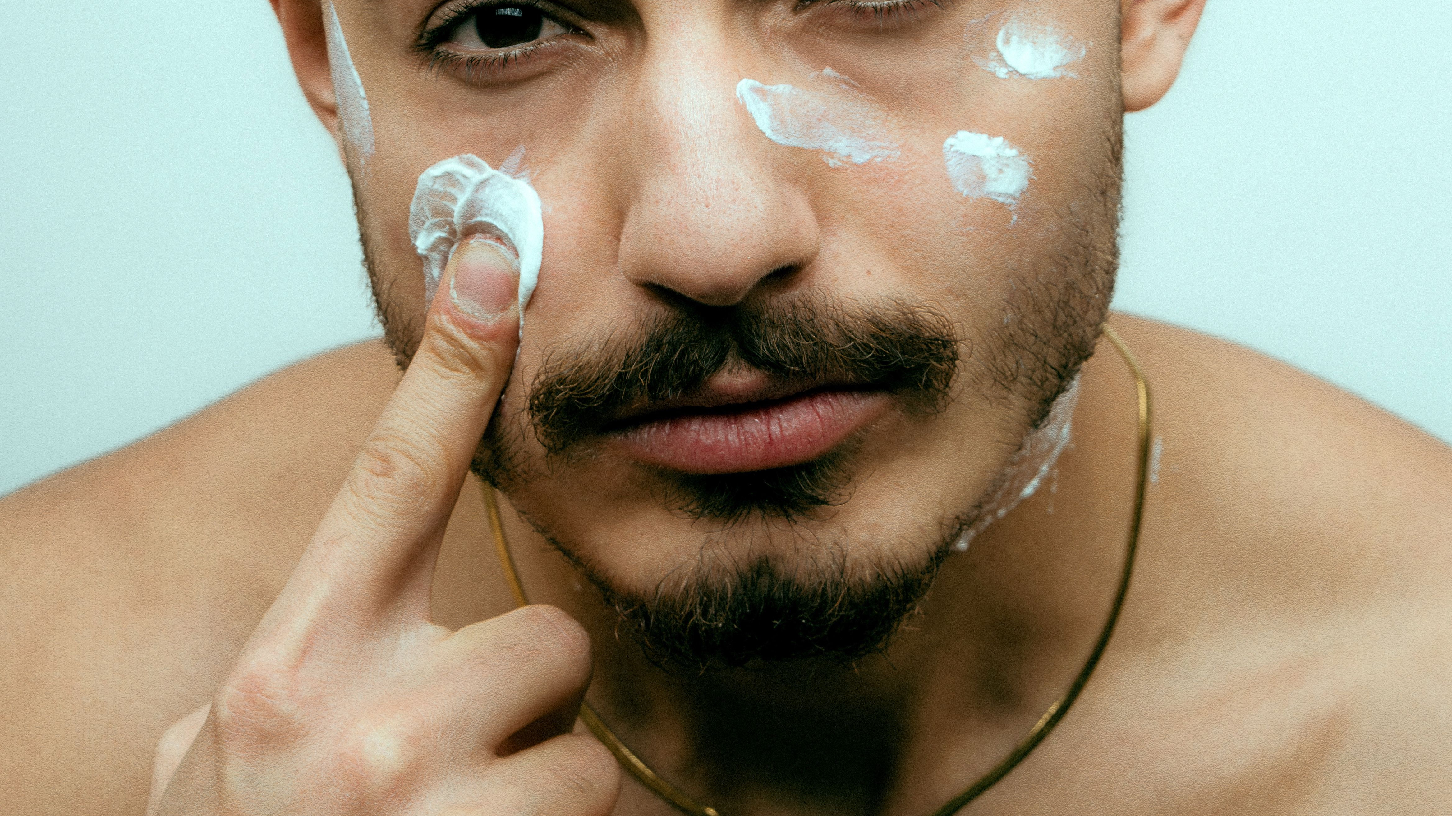 man moisturising face