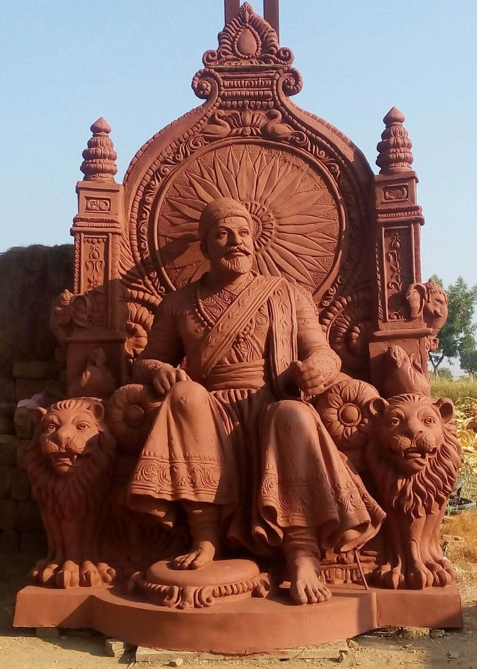 a statue of a man sitting on a throne with two lions