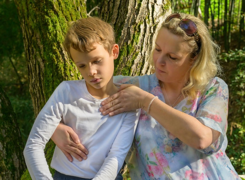 Mutter hält ihre Hände auf der Brust ihres Kindes - Heilströmen