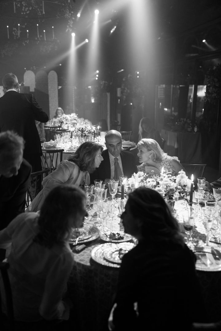 People dining at formal event tables under dramatic spotlights at a wedding dinner party in Richmond, BC