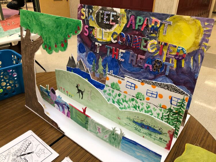 A diorama that says "six feet apart, still connected at the heart"
