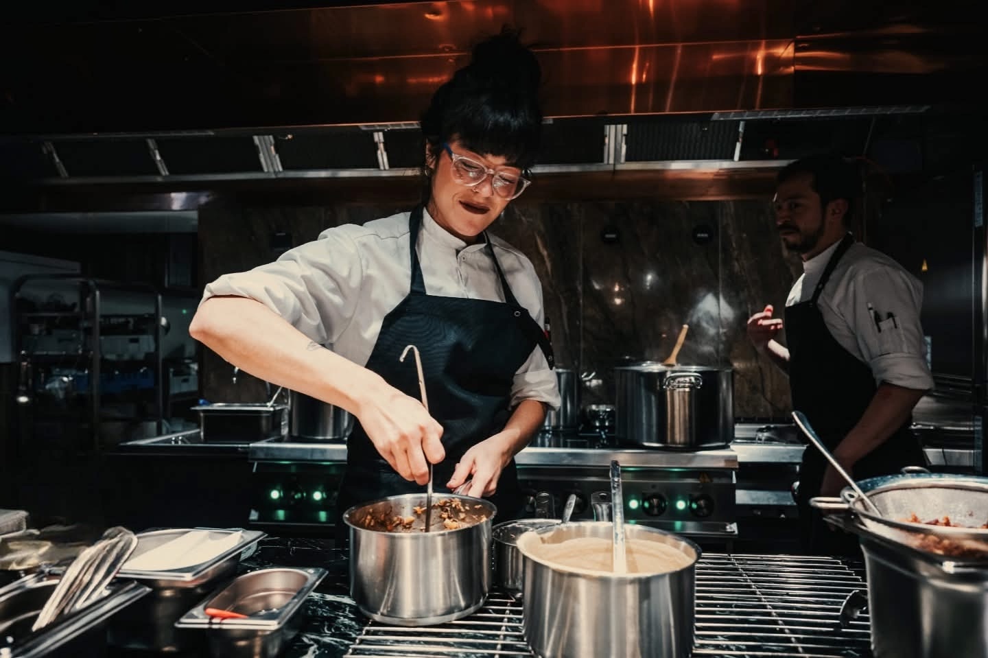 Kokk som tilbereder mat i et travelt restaurantkjøkken