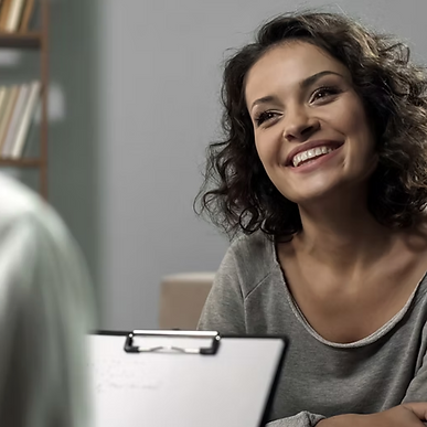 dame som sitter foran en annen person med en blokk