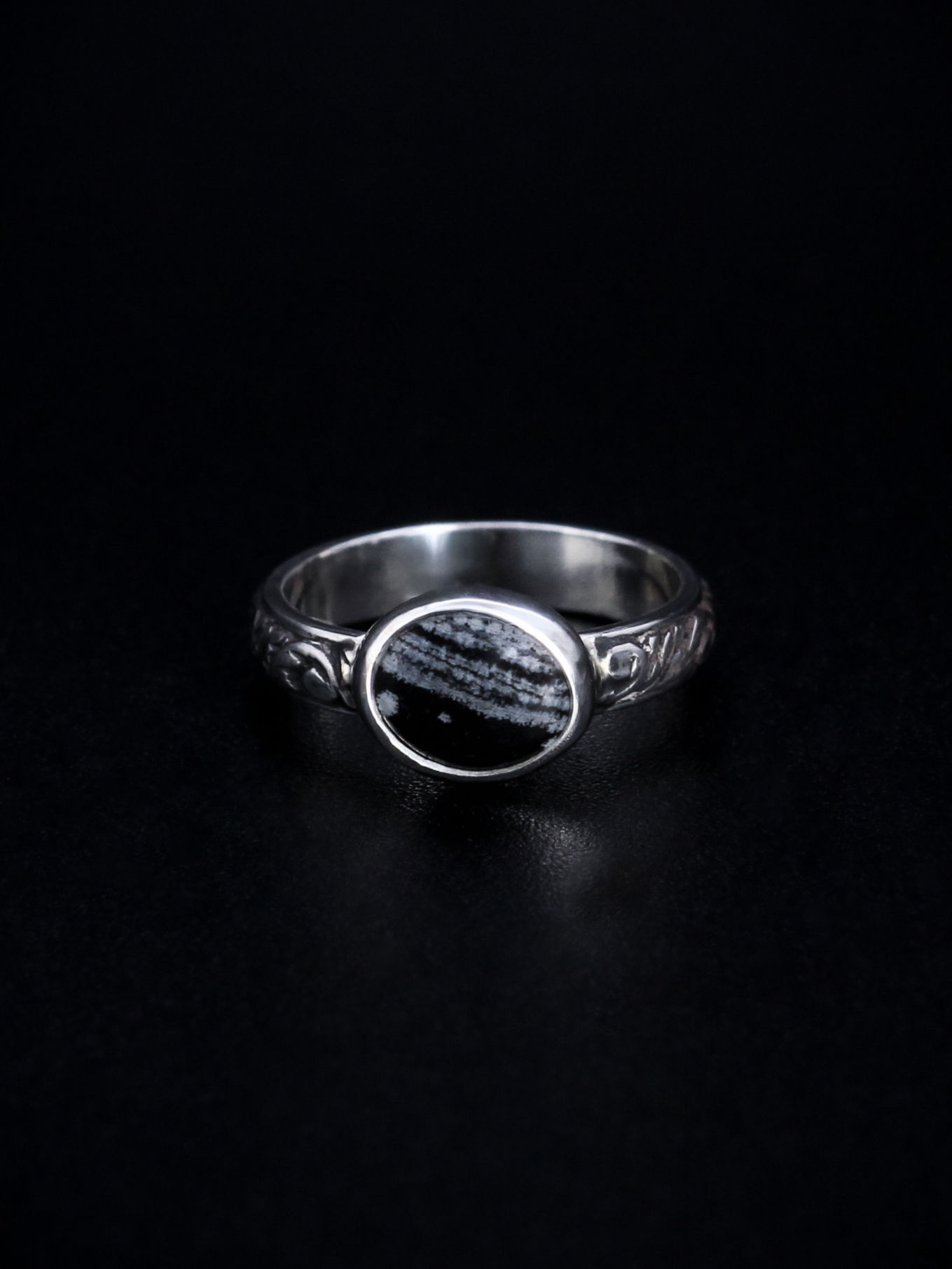 small black and white stone set in sterling silver with detailed band