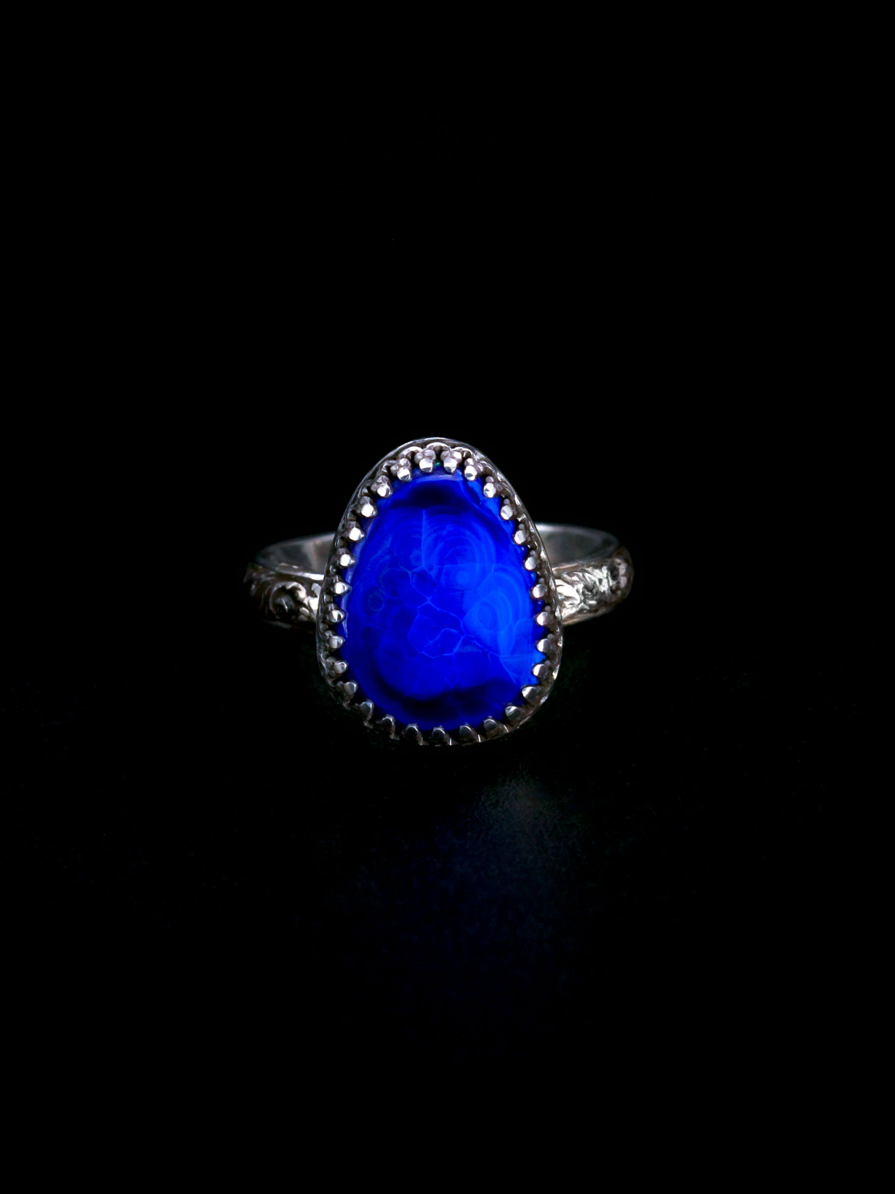 Blue stone in detailed silver ring setting