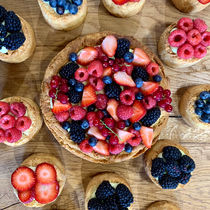 Assortiments de tarte feuilletée briochée aux fruits rouges. On y retrouve des tailles individuelles spécifiques à un fruit (fraises, framboises, mures et myrtilles) et la version grande avec un mélange de tous les fruits rouges.