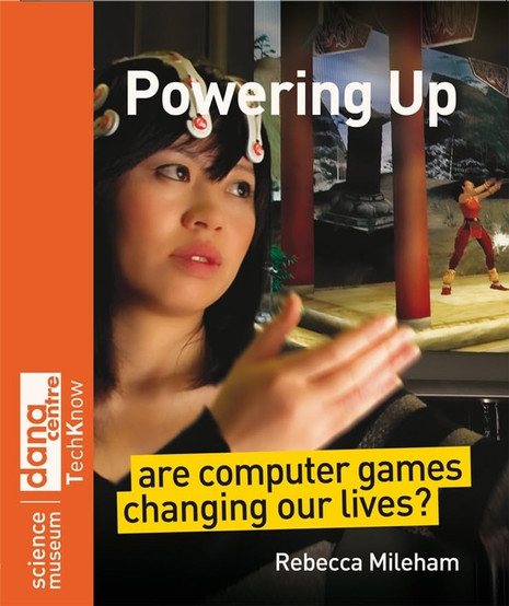The image is the cover of "Powering Up: Are Computer Games Changing Our Lives?" by Rebecca Mileham. The cover features a woman wearing a headset, possibly engaging with technology or virtual reality, set against a backdrop of a video game scene. This visual suggests an exploration of the interaction between humans and digital environments. The book is associated with the Dana Centre at the Science Museum, as indicated on the left side, which implies a focus on the scientific and societal impacts of computer games. The subtitle poses a question about the influence of gaming on our lives, indicating that the book likely examines both positive and negative effects, as well as cultural and technological shifts brought about by gaming. Overall, the cover suggests an analytical approach to understanding the role of video games in modern society.