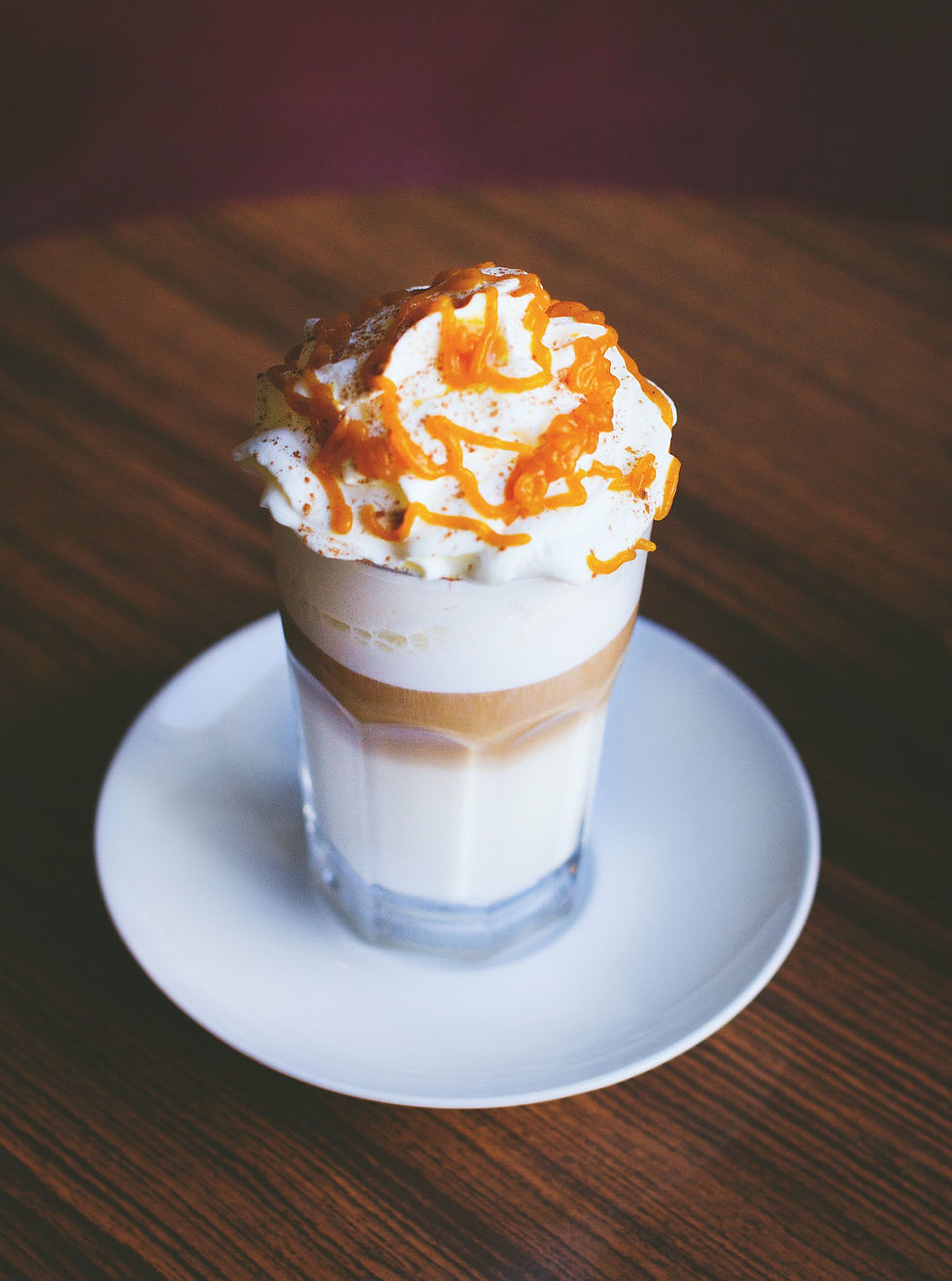 Miniatura: Kawa latte z bitą śmietaną i syropem