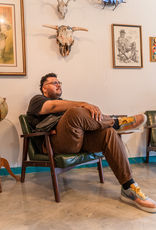 Client in waiting area at Good Times at The Hideout Barbershop.