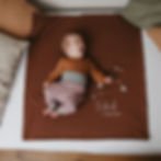 Baby liegt auf mit Sternenbild und Namen personalisierter bestickter Babdecke aus Biobaumwolle von Mafee