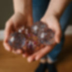 Kinderhände halten fünf Konfetti-Flummi-Bälle von ava&yves in verschiedenen Designs