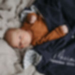 Baby liegt auf einer personalisierten Babydecke mit Sternenbild und Name bestickt aus Biobaumwolle von Mafee