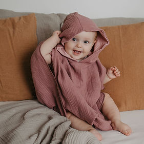 Baby sitzt und trägt Badeponcho aus Musselin Biobaumwolle von Mafee