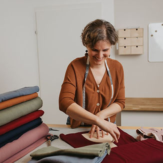 Daniela von Mafee schneidet eine Babymütze aus Biobaumwollstoff zu
