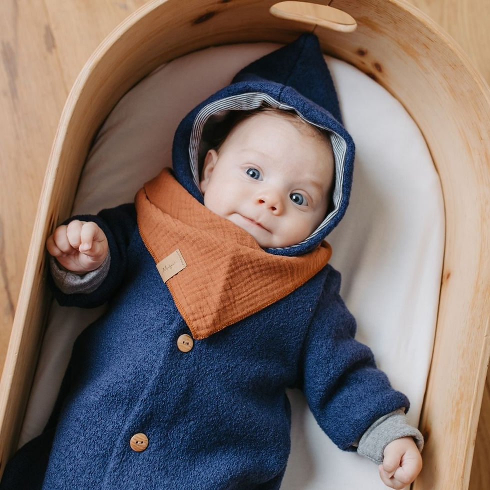 Baby liegt auf dem Rücken mit Wollwalkanzug in blau aus Merinowolle mitwachsend von Mafee
