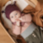 Baby liegt auf dem Rücken und hat die Hände im Mund, trägt Babyhose Cord aus Biobaumwolle von Mafee