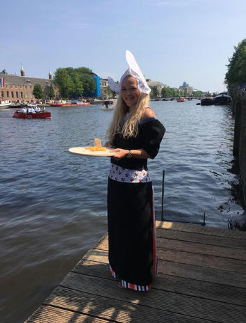 Dutch girl in traditional clothing handing out cheese during teambuilding game