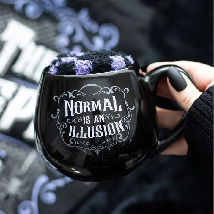 Black mug with text 'Normal is an illusion'