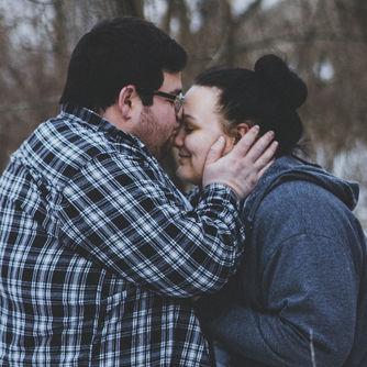 Close-up of an affectionate couple embracing outdoors, illustrating how sex therapy supports intimacy and connection.