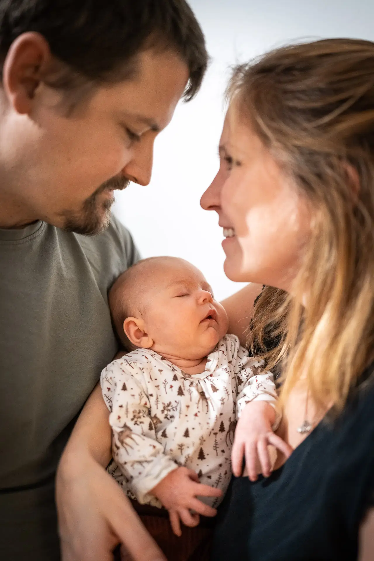 Neugeborenes Baby mit Eltern im Wohnzimmer
