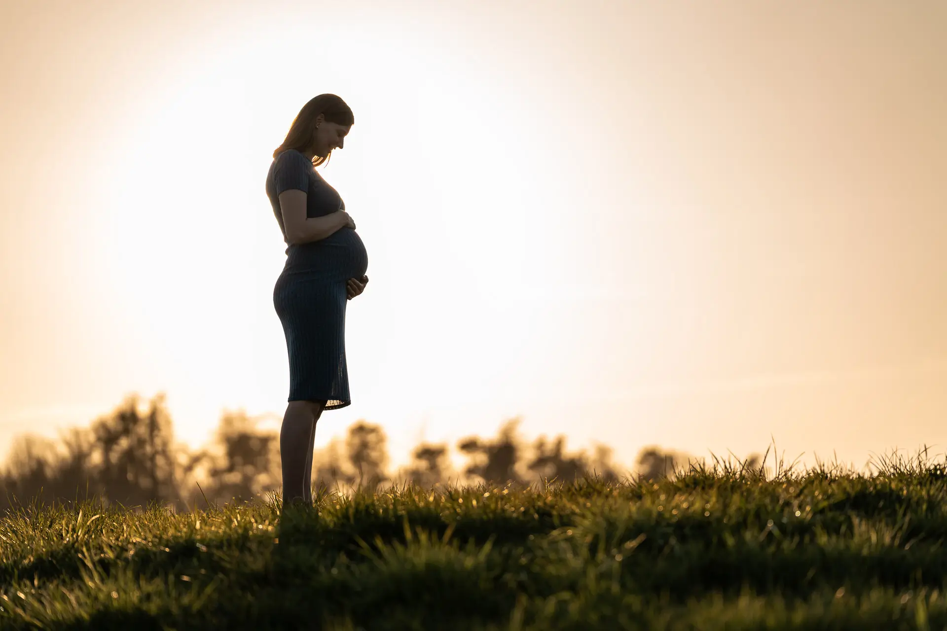 Silhouette einer werdenden Mutter im Abendlicht