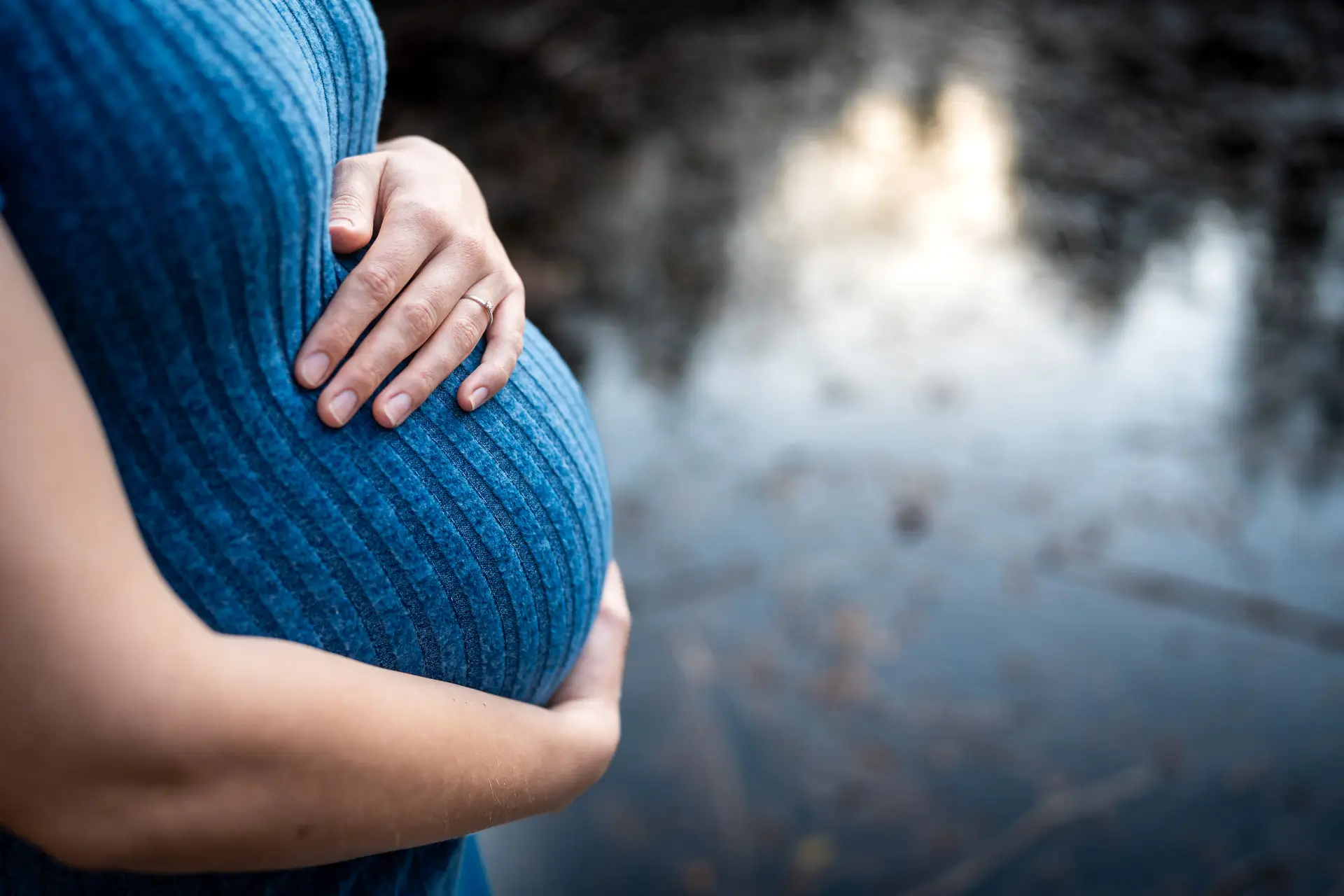 Babybauch im warmen Abendlicht am Weiher
