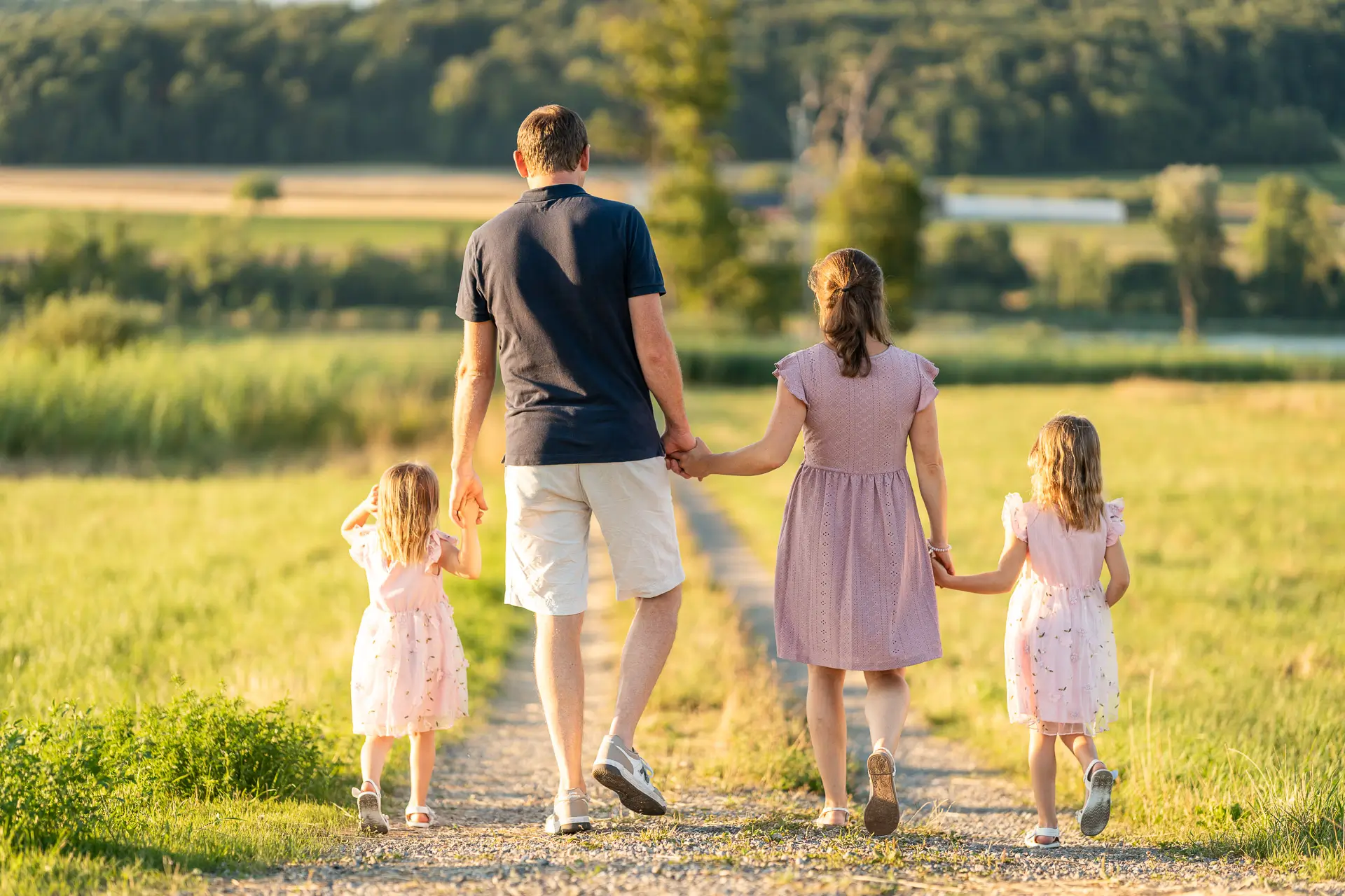 Familie läuft Hand in Hand am See
