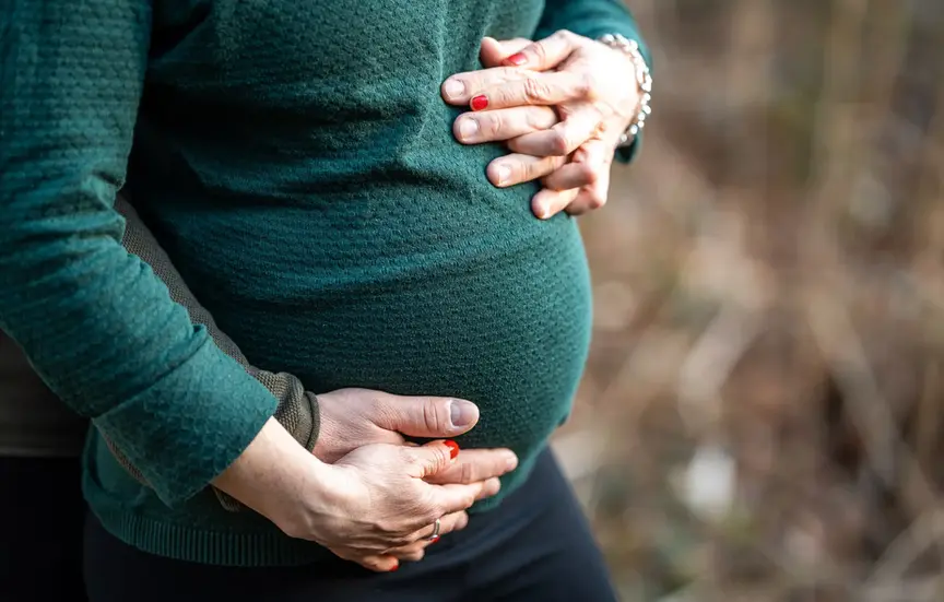 Babybauchshooting im Wald zur goldenen Stunde