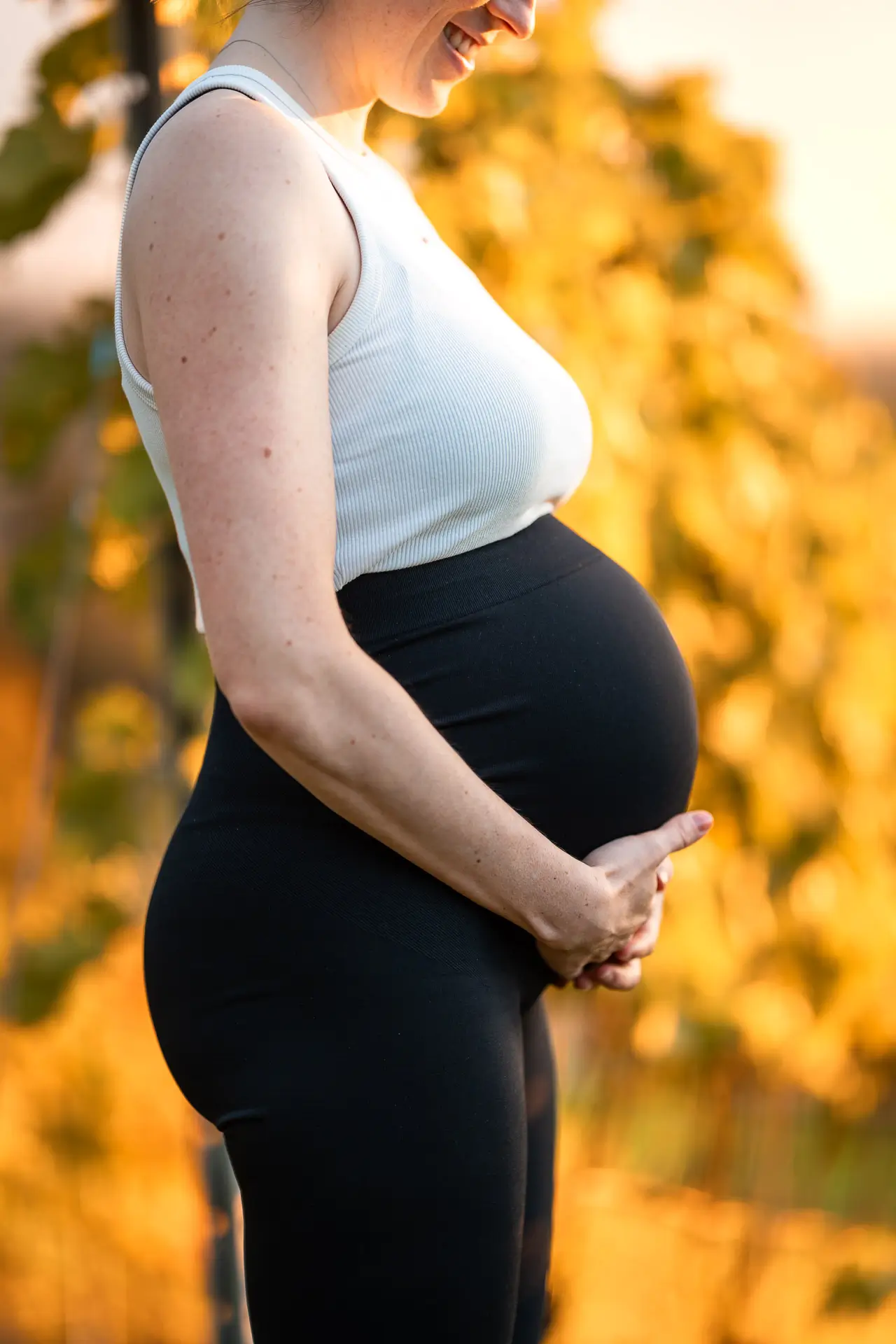 Babybauch im warmen Licht der goldenen Stunde