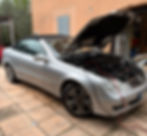 Mercedes CLK 200 cabriolet grise avec capot ouvert, branchée sur un stabilisateur de tension lors d'une reprogrammation et conversion E85 Flexfuel par Sud-Reprog