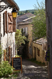 Ruelle bordée de vieilles maisons en pierre dans le village médiéval de Penne dans le Tarn