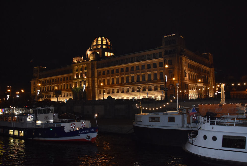 Vue d'un superbe bâtiment à Prague depuis un bateau de croisière de nuit