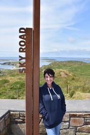 Une femme devant la signalétique de la Sky Road dans le Connemara en Irlande.