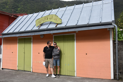 Des personnes devant une maison créole colorée à Hellbourg dans le cirque de Salazie à La Réunion