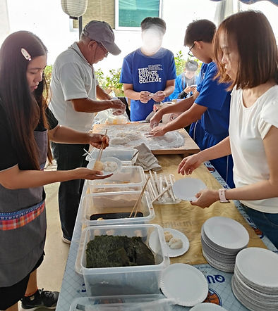つき上がった餅に味付けをして皿に盛りつける作業