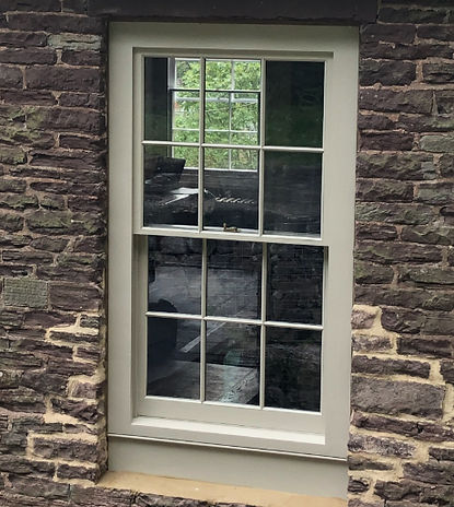 sliding sash window on a dark stone building