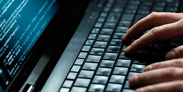 Des doigts d'hommes sur un clavier d'ordinateur portable