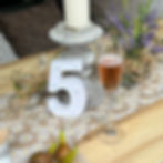 Eine Leuchtzahl 5 und ein Sektglas auf dekoriertem Tisch