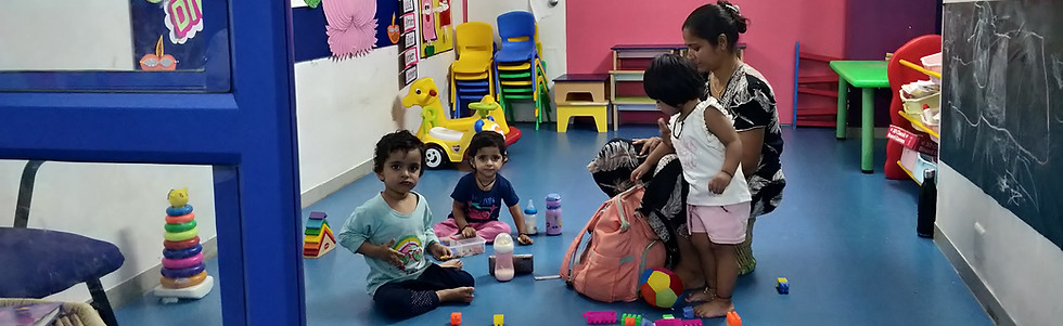 Toddlers settling into the classroom with teachers and colorful play equipment.