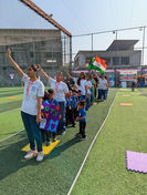 Teachers and students marching with the national flag during a patriotic school celebration.